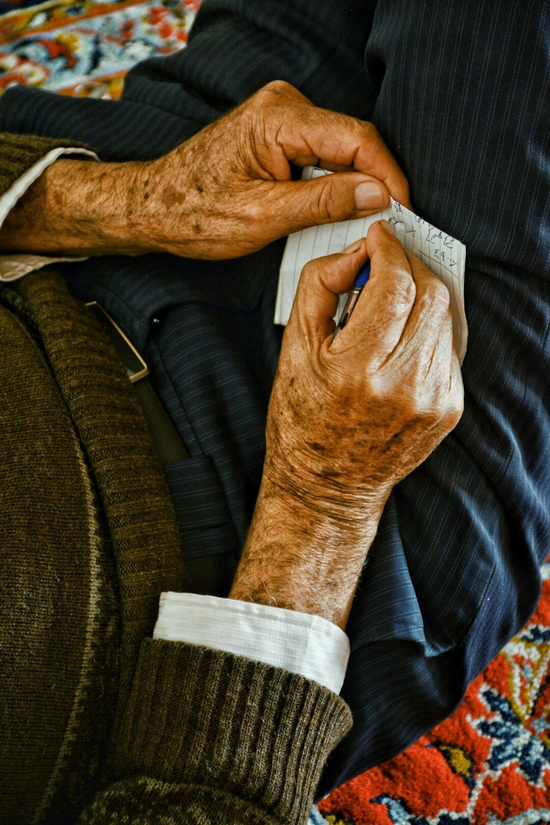 Elderly hands writing a last will and testament document